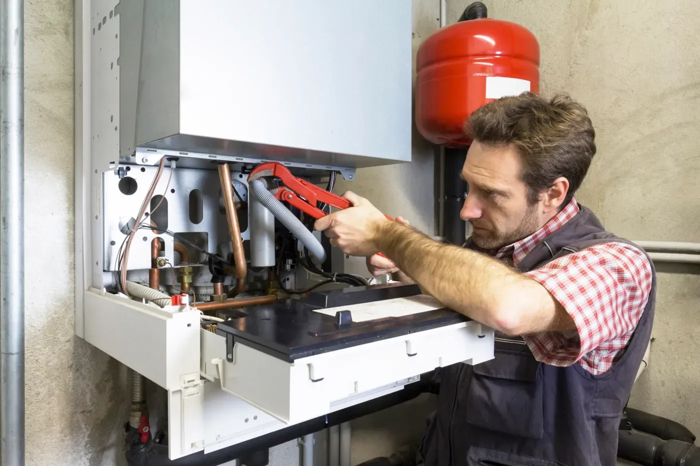 Chauffagiste réglant une chaudière à condensation rénovée à Nanterre
